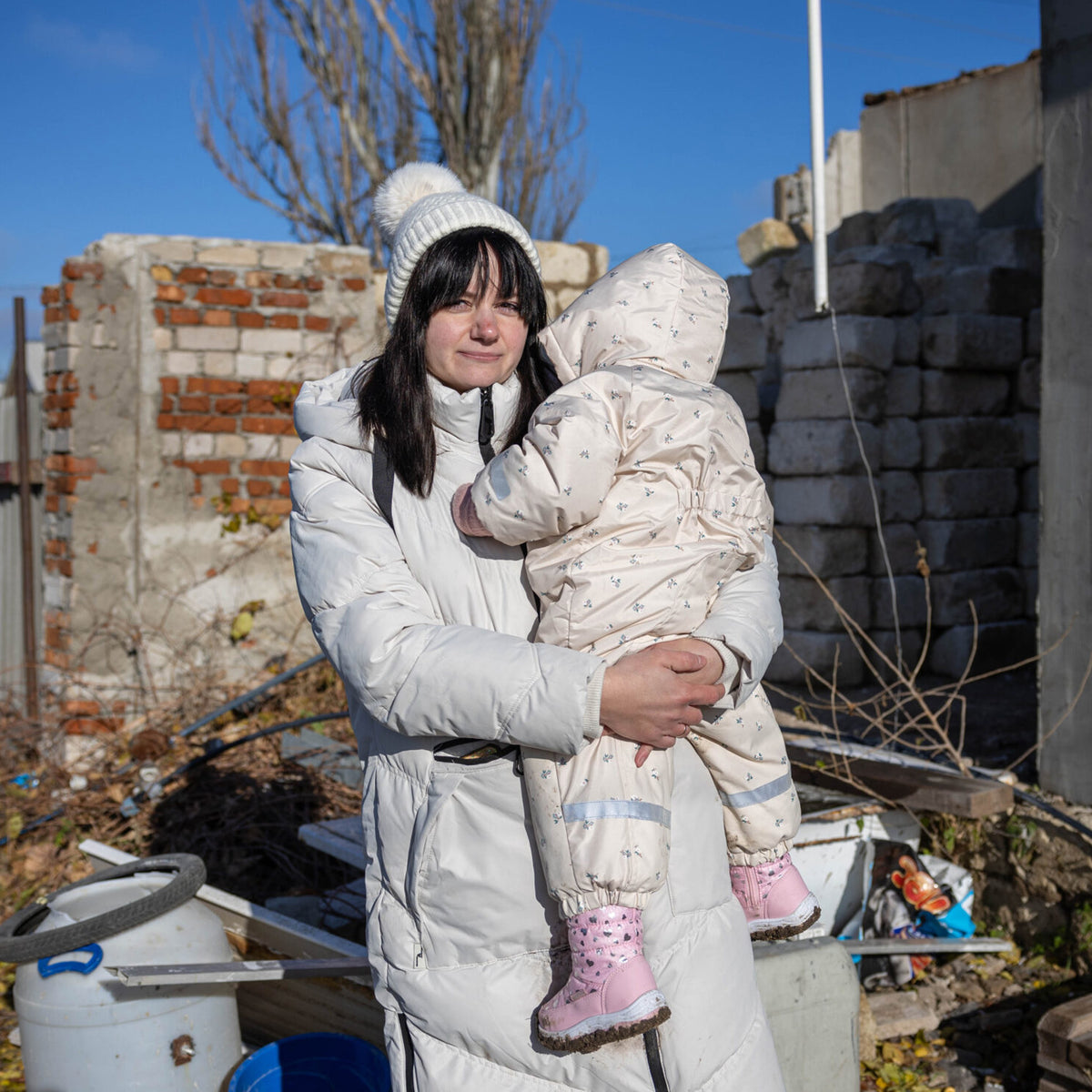 Mor og barn på en kold vinterdag, hvor barnet er iklædt en varm flyverdragt. Folkekirkens Nødhjælp hjælper familier ramt af krigen i Ukraine med varmt vintertøj.