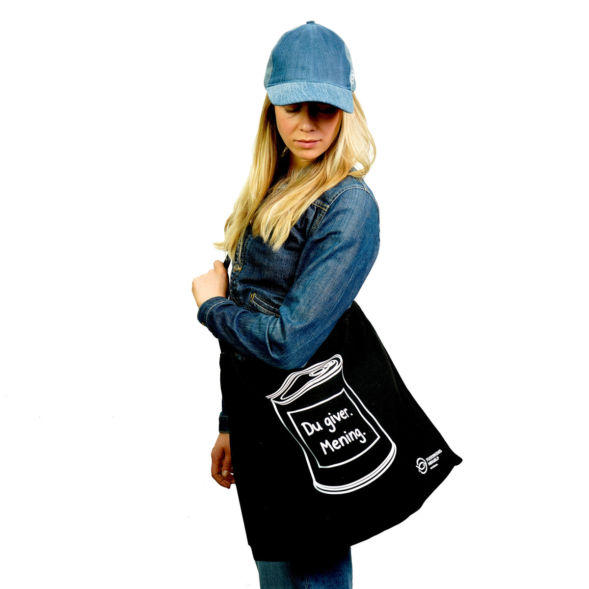 Ung kvinde iført upcyclet denimkasket med totebag båret crossbody over skulderen.
