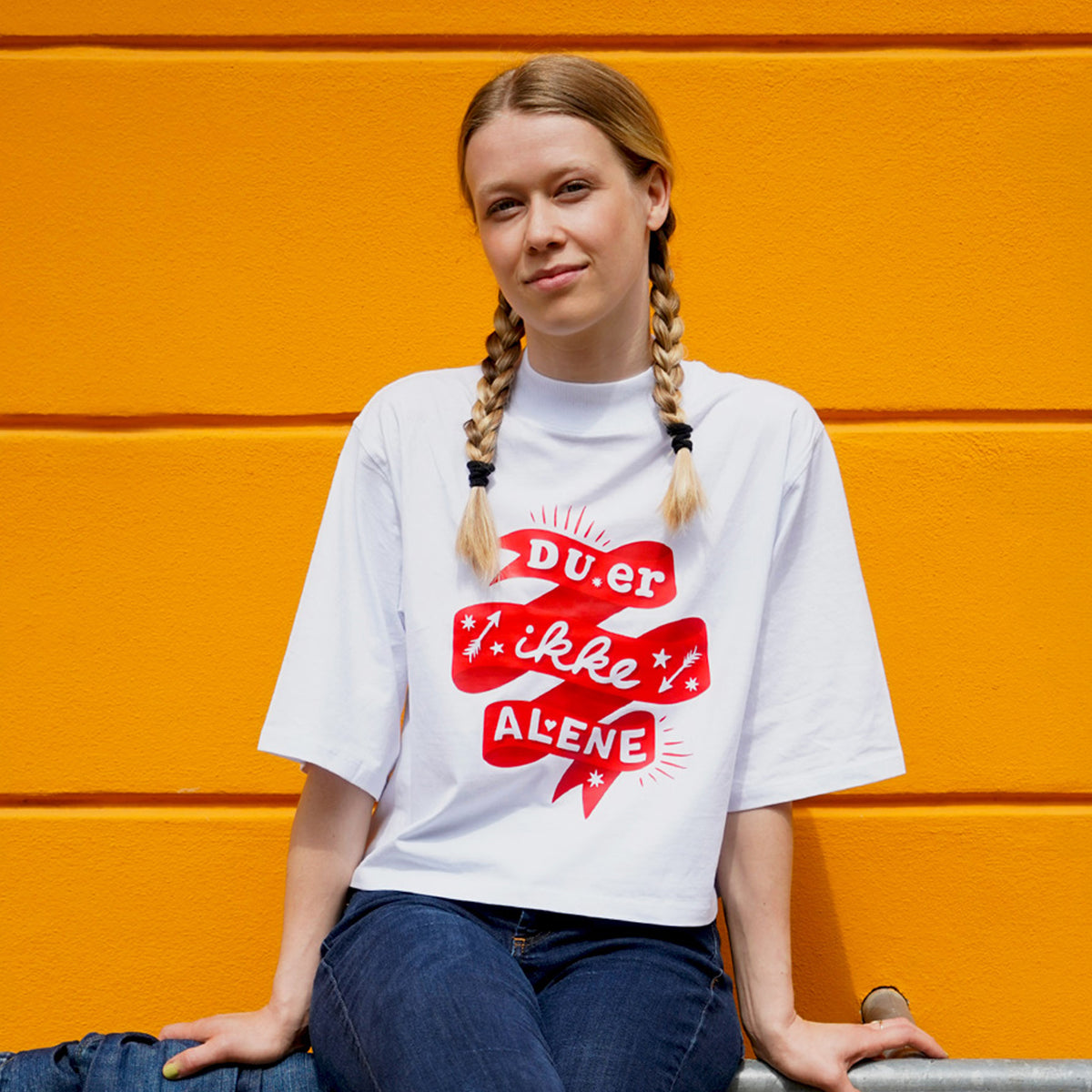 Du er ikke Alene - Ung kvinder iført t-shirt fra Folkekirkens Nødhjælps sommerkollektion.