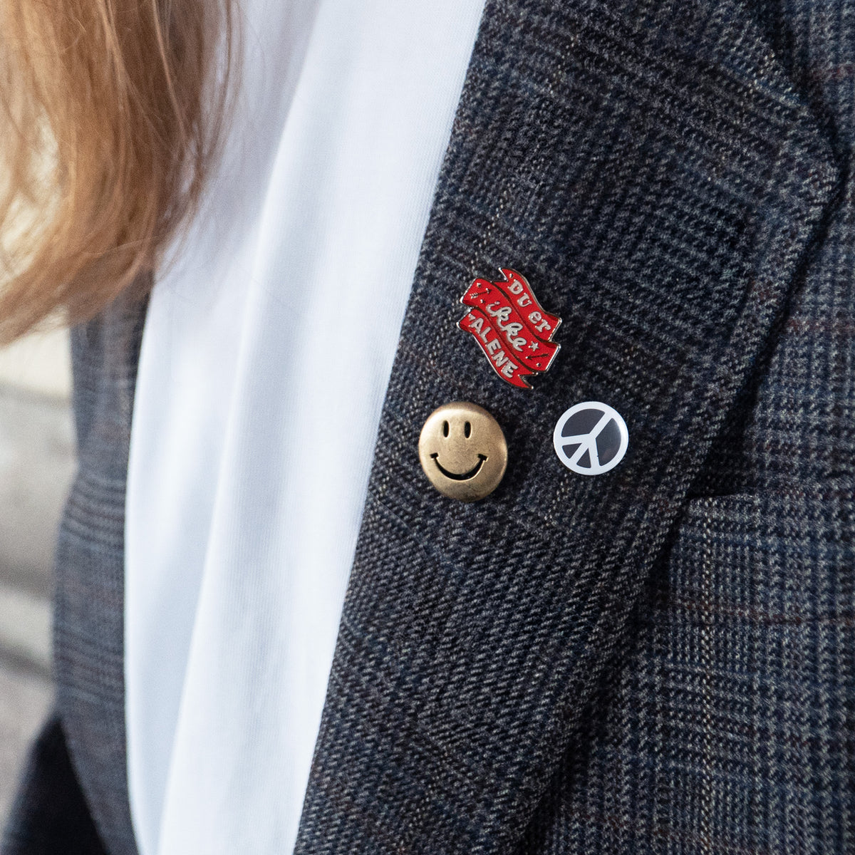 Pin på en jakke - Du er ikke Alene. Folkekirkens Nødhjælp